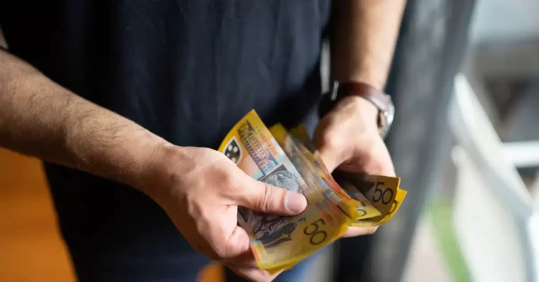 Staff member manually counting Australian banknotes